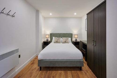 een slaapkamer met een groot bed en 2 nachtkastjes bij Host & Stay - Sevenstays Aparthotel in Liverpool