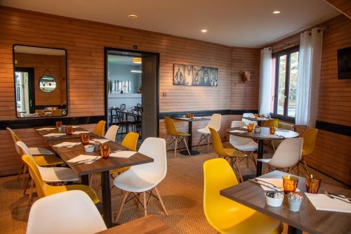 ValletにあるClair de Lieの木製の壁とテーブル、黄色の椅子が備わるレストラン