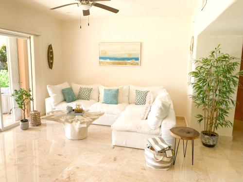 a living room with a white couch and a table at Beachfront Breathtaking Views Puerto Aventuras in Puerto Aventuras