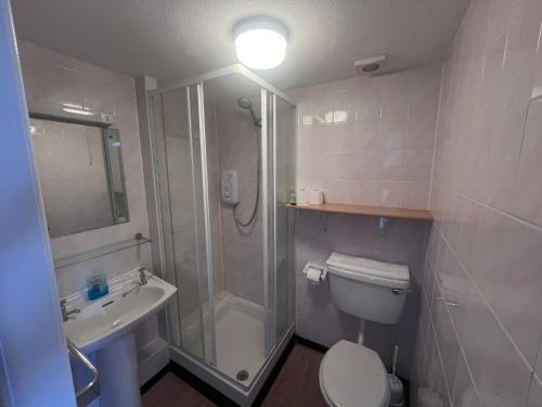 uma casa de banho com um chuveiro, um WC e um lavatório. em Brig Inn Hotel em Aberdeen