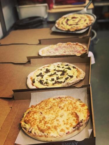 a group of pizzas sitting on top of a table at Hotel Kurikka in Kurikka