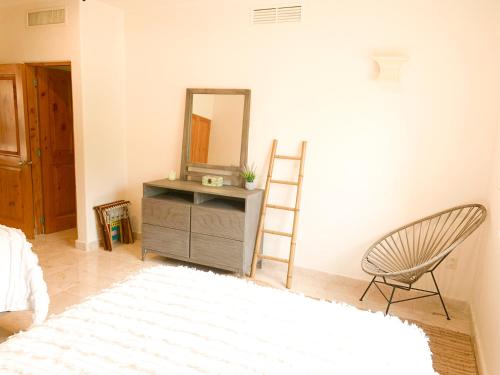 a bedroom with a mirror and a chair and a dresser at Beachfront Breathtaking Views Puerto Aventuras in Puerto Aventuras