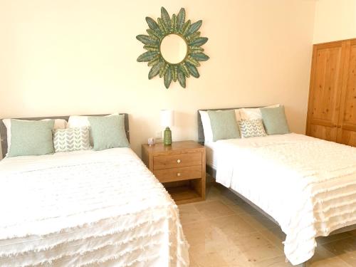 two beds in a room with a mirror on the wall at Beachfront Breathtaking Views Puerto Aventuras in Puerto Aventuras