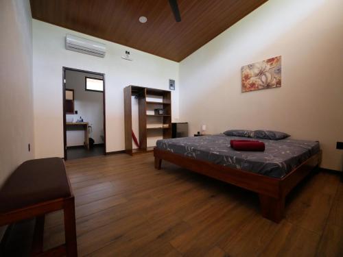 um quarto com uma cama e piso em madeira em Raya em Matapalo