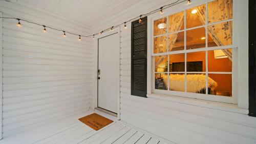 um quarto branco com uma janela e uma porta em Cozy 2b/1ba close to everything em Hattiesburg