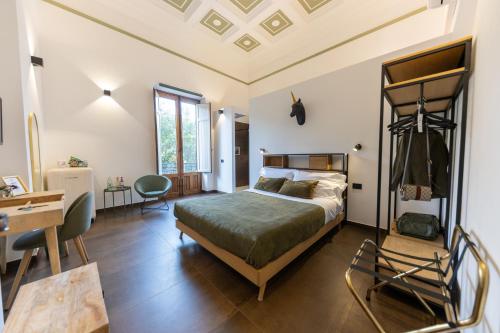 a bedroom with a bed and a desk in a room at Bohémien Boutique Guesthouse in Cefalù