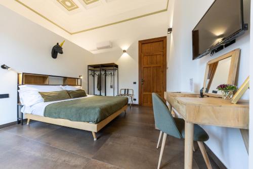1 dormitorio con cama, escritorio y lavamanos en Bohémien Boutique Guesthouse, en Cefalú