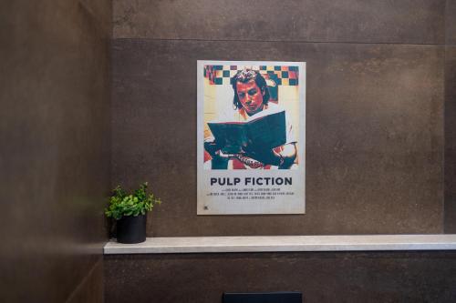 a poster of a woman reading a book on a wall at Bohémien Boutique Guesthouse in Cefalù