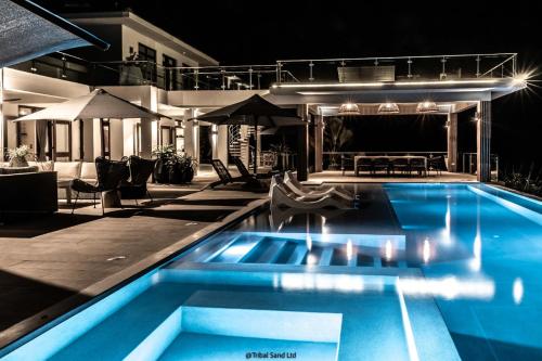 una piscina frente a una casa por la noche en My Amani by Tribalsand, en Vipingo