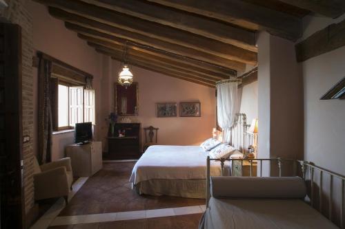 a bedroom with a bed and a couch in a room at Hotel BOUTIQUE HOCES DEL DURATON in Sebúlcor