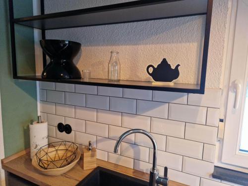 a kitchen counter with a sink and a shelf at Ferienwohnung am Wasserfall in Nohn