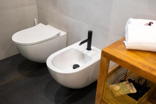 a bathroom with a white toilet and a sink at Bohémien Boutique Guesthouse in Cefalù