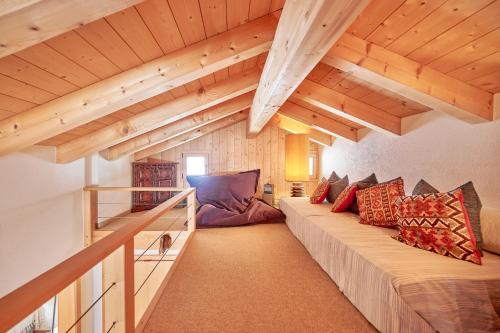 - une chambre avec un long canapé dans une chambre dotée de plafonds en bois dans l'établissement Eagle's Nest, à Grindelwald