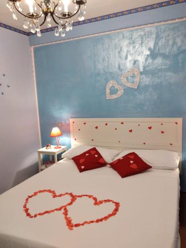 1 dormitorio con 2 corazones pintados en una cama en Casadinonnabella, en Biella