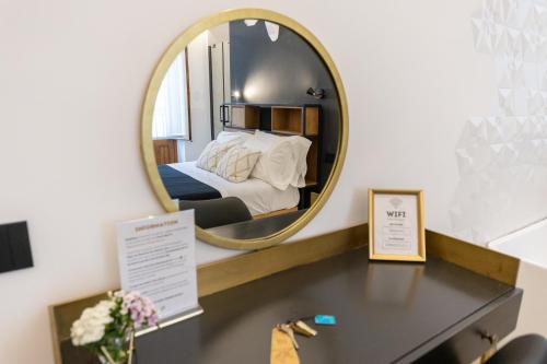a mirror over a desk with a bed in a room at Bohémien Boutique Guesthouse in Cefalù