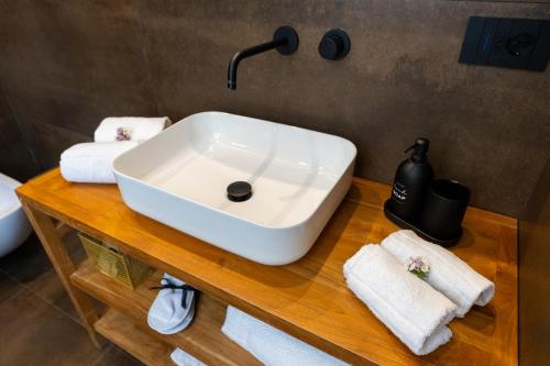 a bathroom sink on a wooden table with towels at Bohémien Boutique Guesthouse in Cefalù