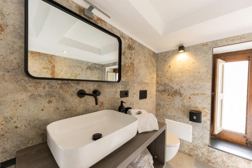 a bathroom with a sink and a mirror at Bohémien Boutique Guesthouse in Cefalù