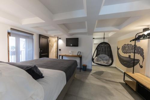 a bedroom with a large bed and a swing at Bohémien Boutique Guesthouse in Cefalù