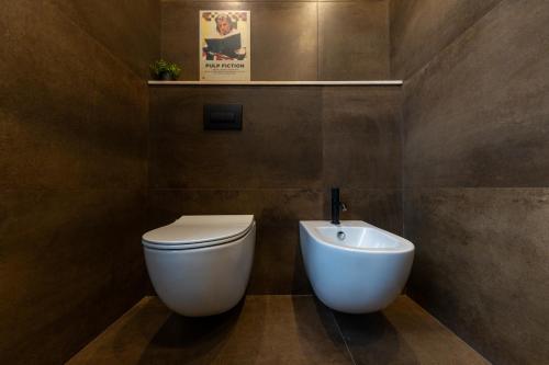 a bathroom with a white toilet and a sink at Bohémien Boutique Guesthouse in Cefalù
