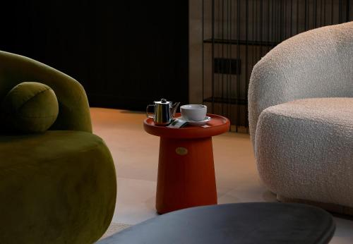 a coffee cup on a table next to a chair at Nuvō Hotel Boutique in Oviedo