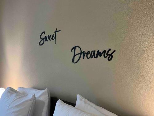 a sign that says sweet dreams on a wall above a bed at Hill Country Hiatus! in Austin