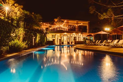 une piscine devant une maison la nuit dans l'établissement Recanto Da Paz Hotel Fazenda, à Atibaia