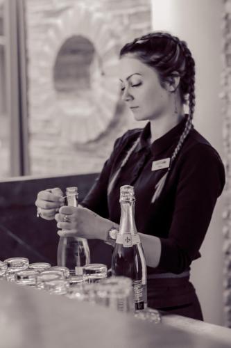 a woman sitting at a table with two bottles at Hotel Kurikka in Kurikka