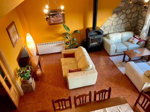a living room with a couch and a fireplace at Luna de Gredos in Pedro Bernardo