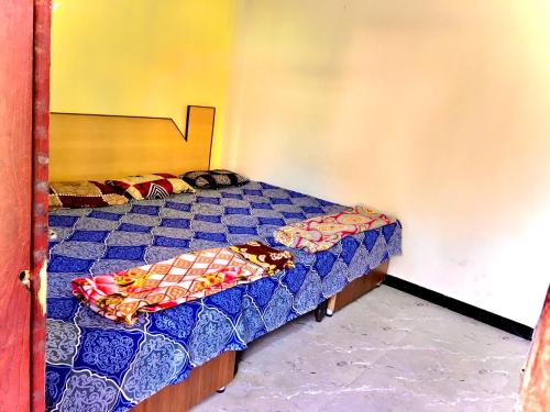 1 dormitorio pequeño con 1 cama de color azul en Jai Shree Narsingh Guest House, en Ujjain