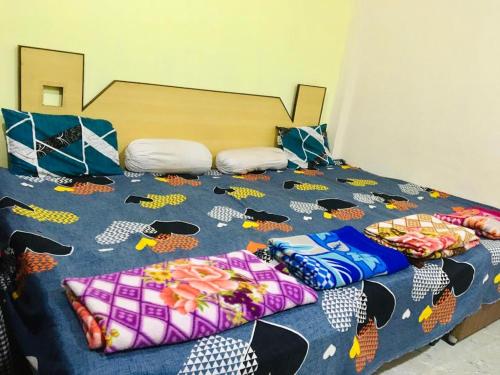 Una cama con un edredón azul con sombreros. en Jai Shree Narsingh Guest House, en Ujjain