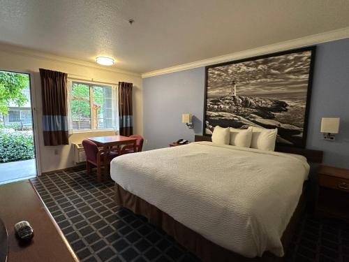 a hotel room with a large bed and a desk at Creekside Inn & Suites in Willits