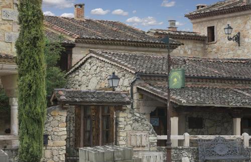 an old stone building with a green sign on it at Hotel BOUTIQUE HOCES DEL DURATON in Sebúlcor