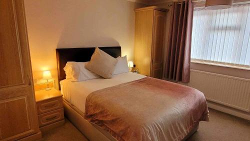 a bedroom with a large bed and a window at Church Farm Guest House in Horsford