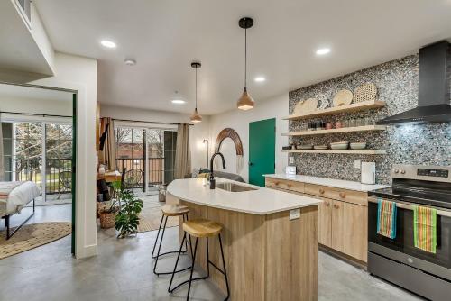 a kitchen with a sink and a counter with stools at Maven STAY in Salt Lake City
