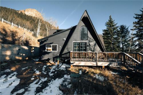 una casa con porche y terraza en la nieve en Modern A-Frame - Mountain Views - Evergreen, en Evergreen