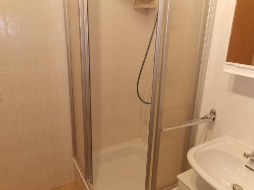 a shower with a glass door next to a sink at Ferienwohnung Anna in Monplaisir