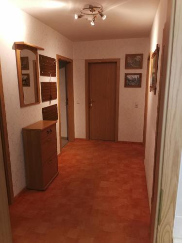 an empty room with a hallway with a wooden floor and a door at Ferienwohnung Anna in Monplaisir