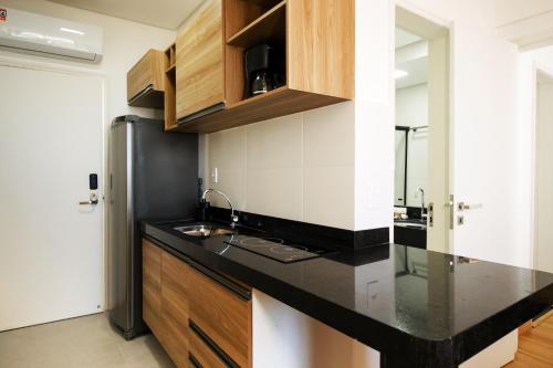 a kitchen with a black counter top and a refrigerator at Ilhéus Praia Hotel in Ilhéus