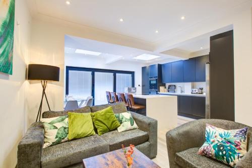 sala de estar con 2 sofás y cocina en Exquisite 5-Bedroom in London and Essex - Sleeps 10 with Free Parking, en Romford