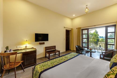 a hotel room with a bed and a television at Sterling ReWild Sariska in Tehla