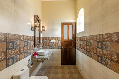 a bathroom with a sink and a toilet at Sterling ReWild Sariska in Tehla