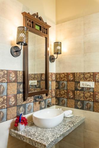 a bathroom with a sink and a mirror at Sterling ReWild Sariska in Tehla