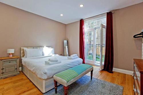 a bedroom with a large bed and a window at Spacious 3bed kensington in London