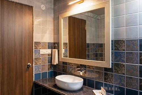 a bathroom with a sink and a mirror at Sterling ReWild Sariska in Tehla