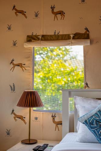 a bedroom with deer decals on the wall at Sterling ReWild Sariska in Tehla