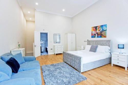 sypialnia z łóżkiem i niebieską kanapą w obiekcie Outstanding 1 bed duplex w Londynie