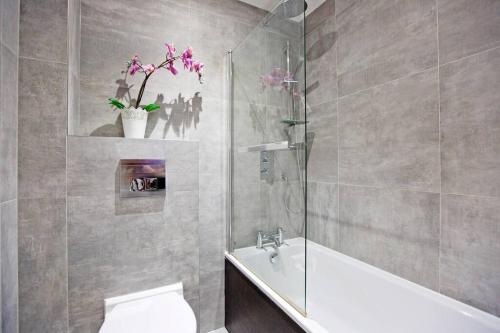 y baño con bañera, aseo y lavamanos. en Beautiful 1bed with Balcony, en Londres
