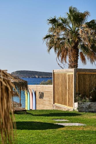 a house with a fence and a palm tree at Golden Beach Hotel in Chrissi Akti