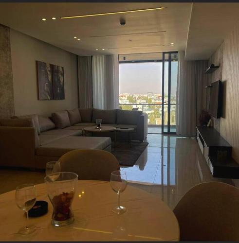 a living room with a couch and a table with wine glasses at Luxury 2-bedroom Apartment Abdoun tower in Amman