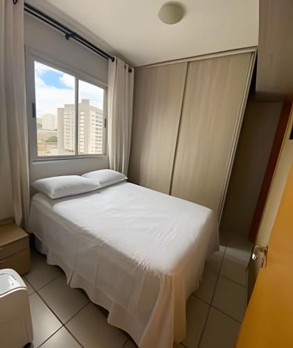 uma cama num quarto com uma grande janela em Ap c/Garagem, Elevador, Cozinha Completa, Lava e Seca, Jr Catito em Brasília